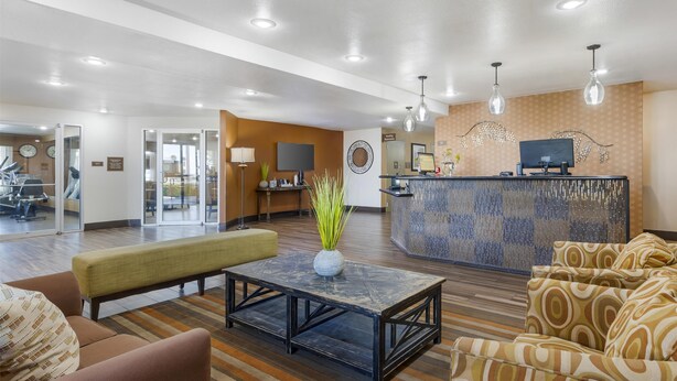 A hotel lobby with a reception desk, seating area, and exercise room. - Best Western East El Paso Inn (Clint)