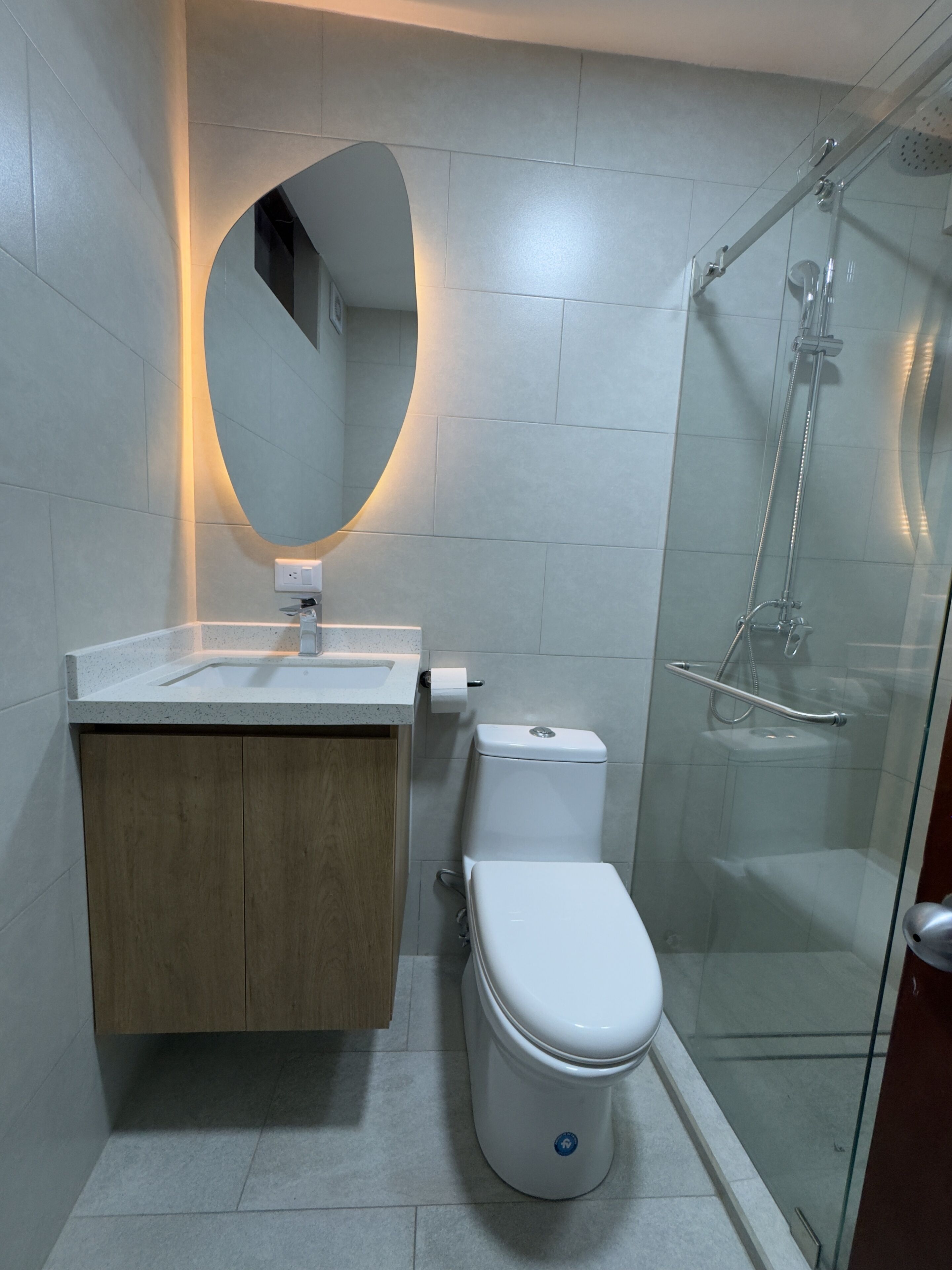 A modern bathroom with a toilet, sink, and shower.