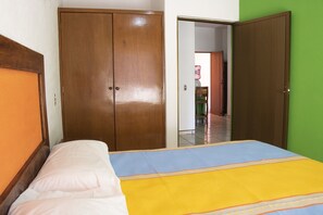A bedroom with a bed, a wardrobe, and a green wall. - Hotel Bahía (San Patricio Melaque)