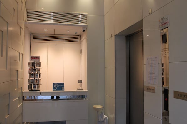 A reception area with a counter, a bulletin board, and a reception desk. - Mingle Place At The Eden (Hong Kong)