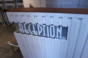 A reception desk with a sign that reads "RECEPTION". - Mingle Place At The Eden (Hong Kong)
