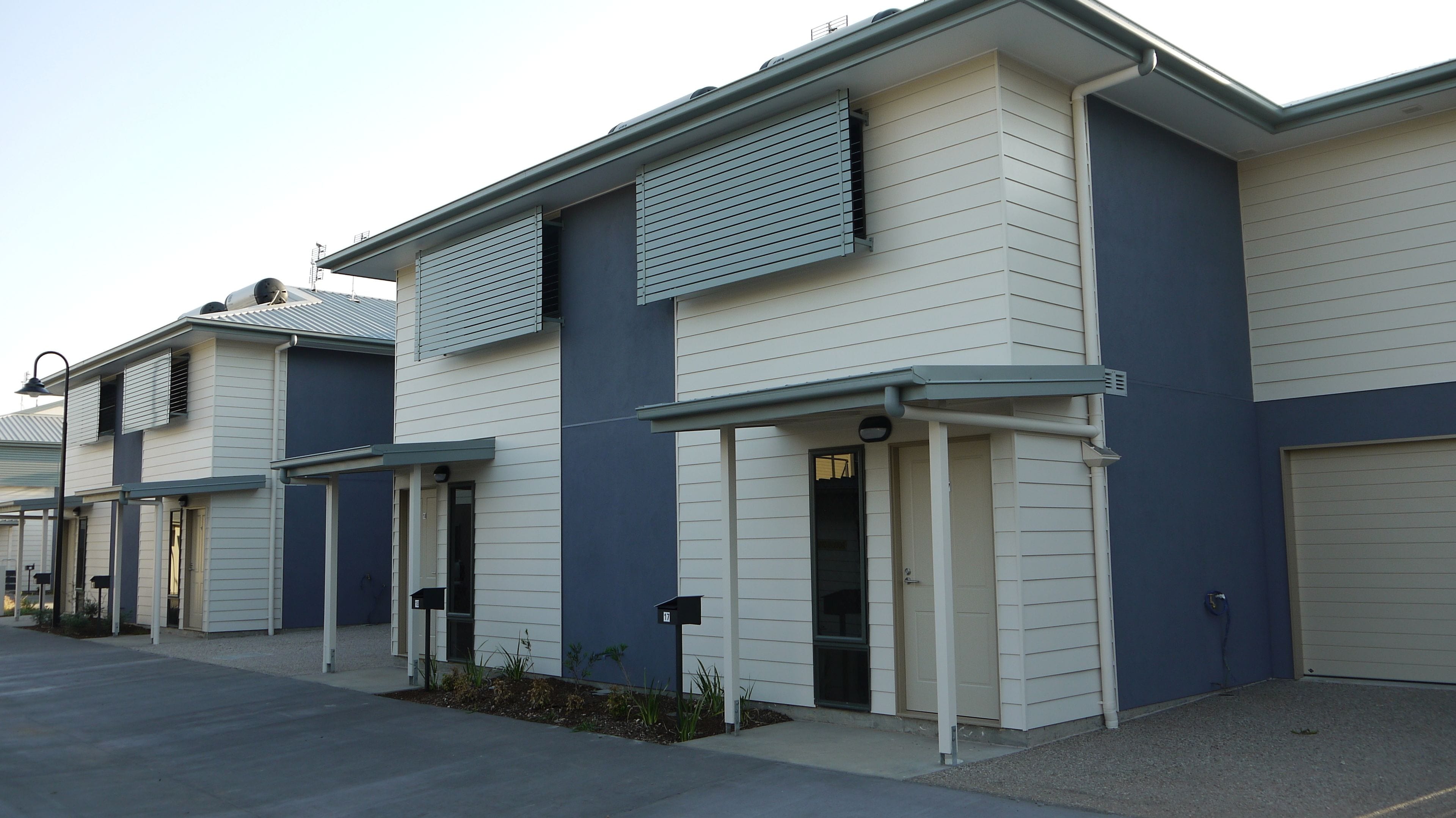 A row of modern, single-story buildings with flat roofs and large windows.