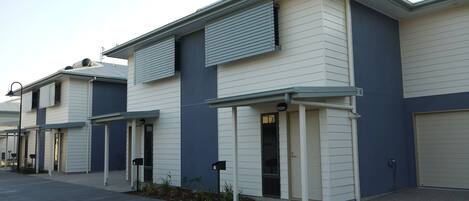 A row of modern, single-story buildings with flat roofs and large windows.