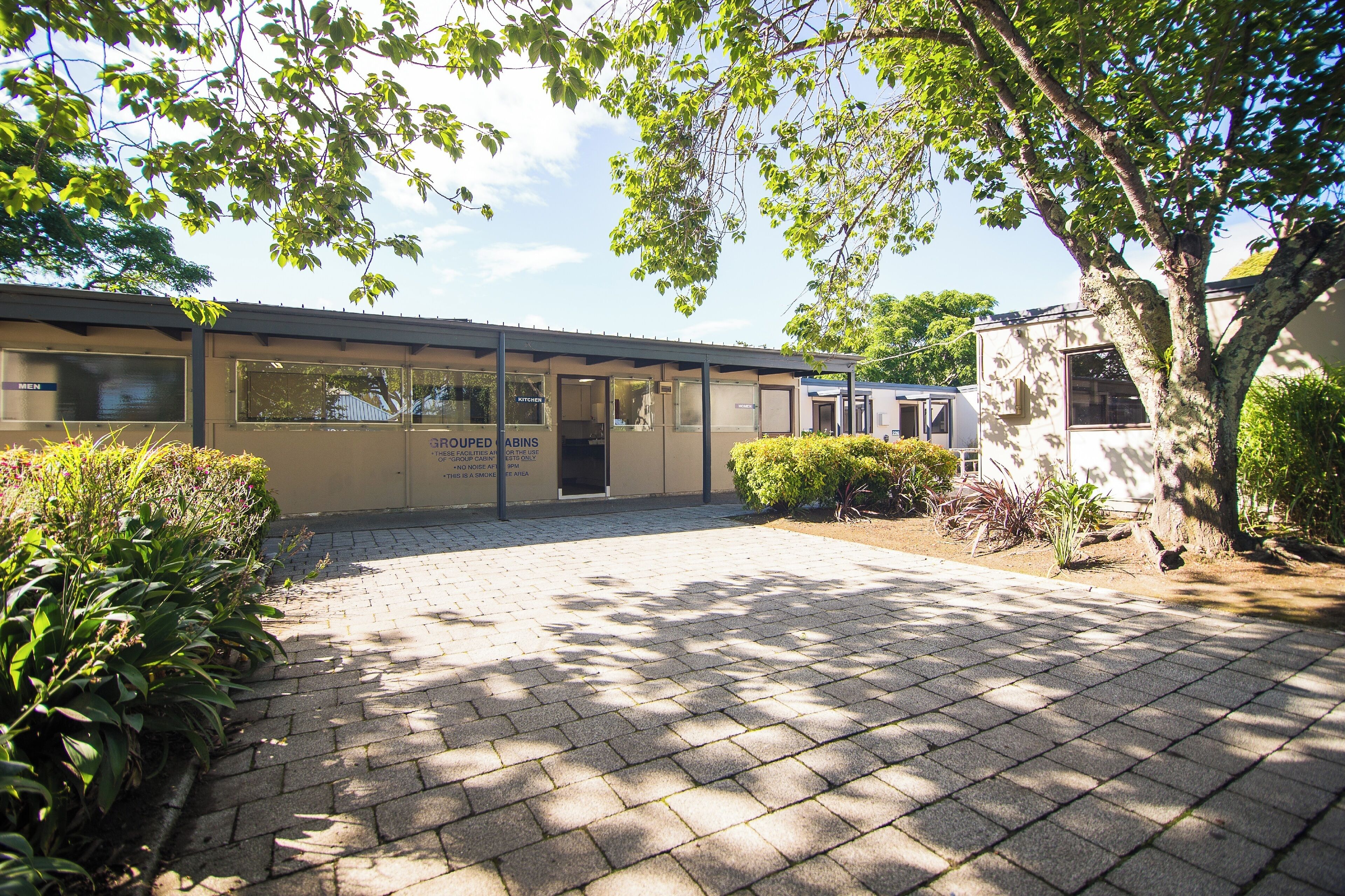 A building with a sign reading "GROUPED CABINS" and a paved entrance area.