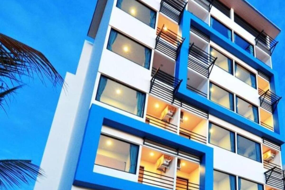 Un hôtel à plusieurs étages au design moderne, doté de balcons et de grandes fenêtres.