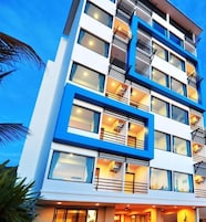 Un hotel de varios pisos con un diseño moderno, que cuenta con balcones y ventanas amplias.