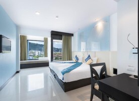 Un hotel moderno con una cama grande, un escritorio y vistas a la ciudad.