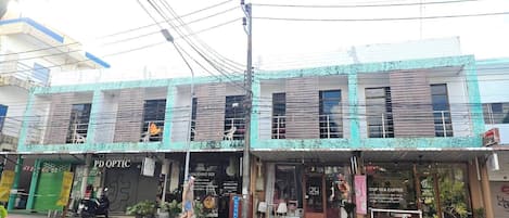Un immeuble de deux étages abritant un café et un restaurant au rez-de-chaussée.