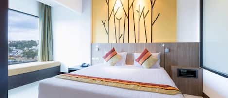 Une chambre d’hôtel moderne avec un grand lit, une vue sur la ville et un mur décoratif.