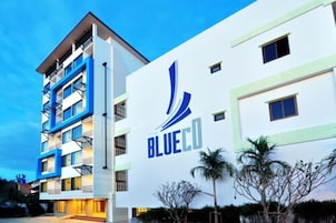 Un edificio moderno de hotel con un logo destacado, varios pisos y balcones.