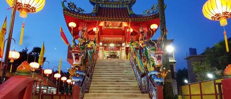 Entrada a un templo chino tradicional, decorada ricamente con motivos de dragones y faroles.