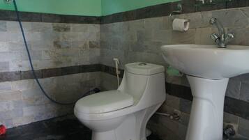 A bathroom with a toilet, sink, and shower.