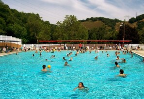 A large outdoor swimming pool with people swimming and playing in the water. - Morgan Hill RV Resort - Campsite (Gilroy)