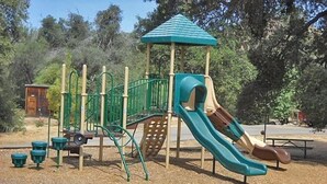 A playground with a slide and climbing structures. - Oakzanita Springs RV Campground (Descanso)