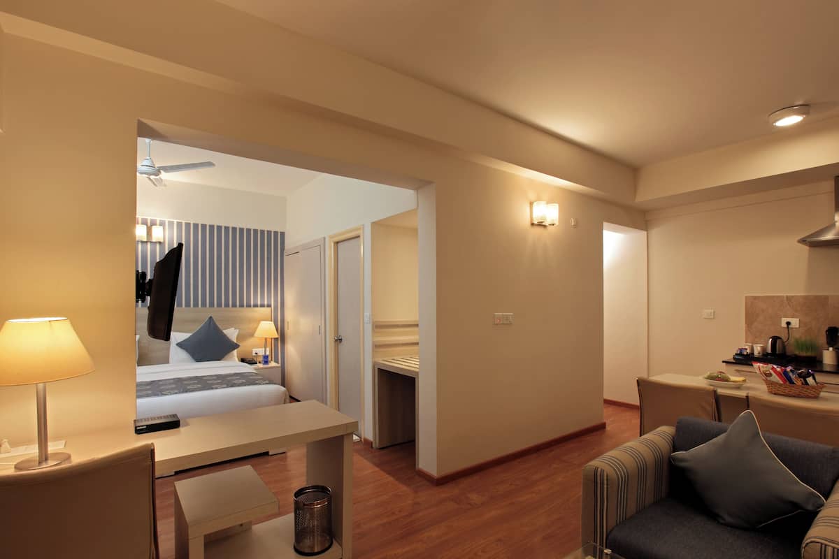 A hotel room with a bed, desk, chair, and a small table.