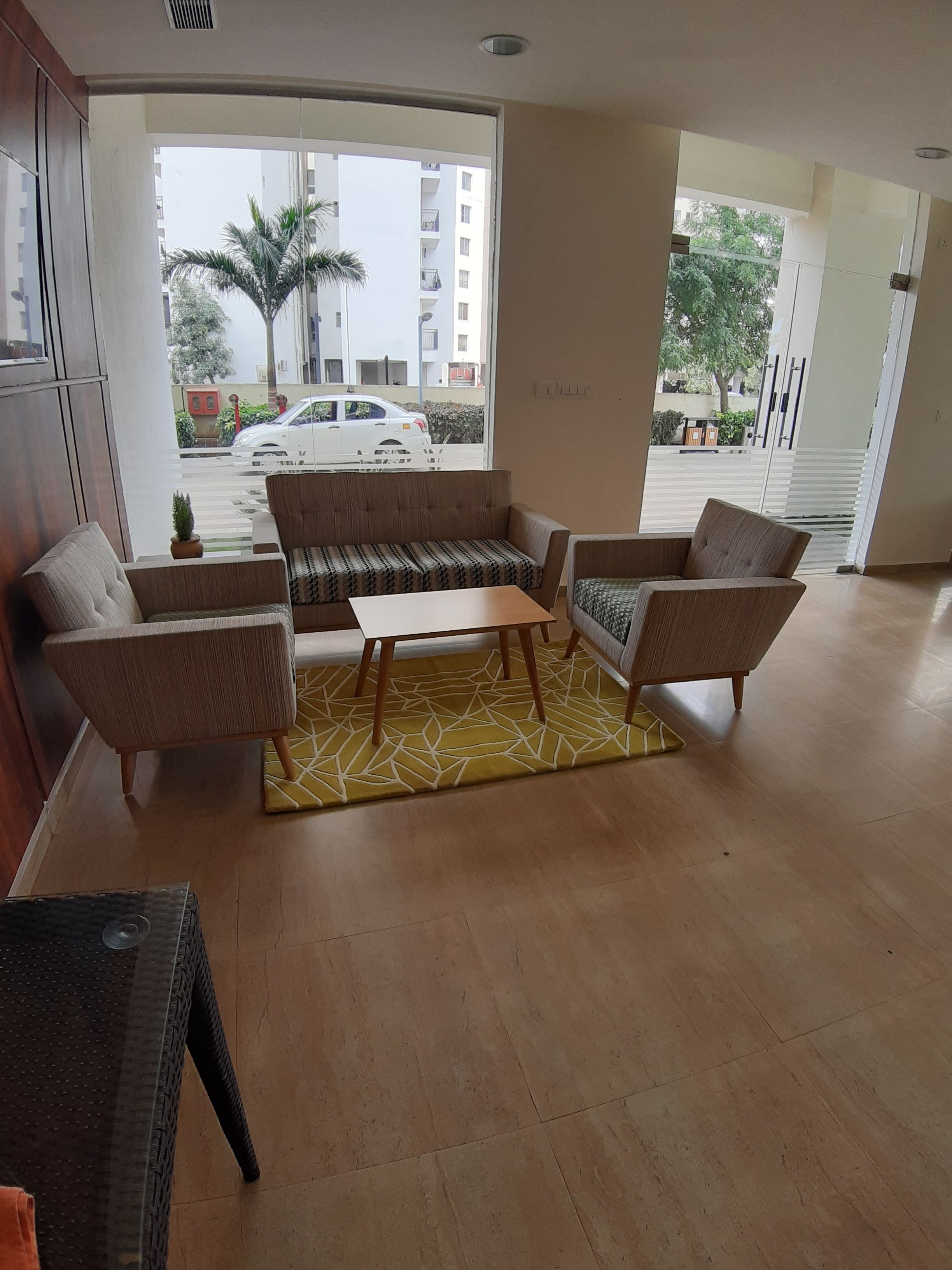 A spacious living room with a sofa set, a coffee table, and a patterned rug.