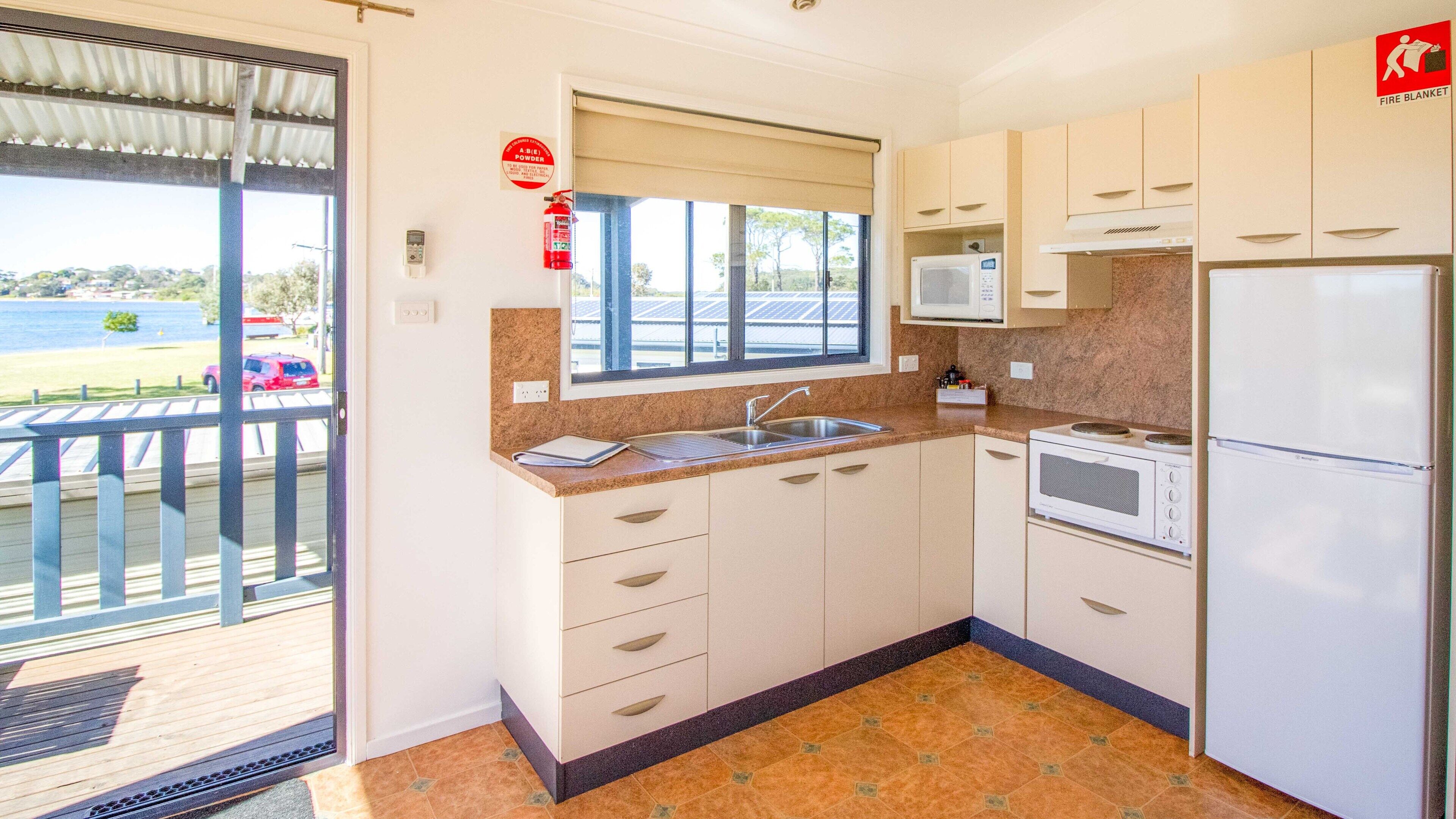 A compact kitchen with a sink, microwave, and refrigerator.