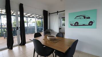 Un coin repas avec une table en bois, des chaises noires et un panier en osier.