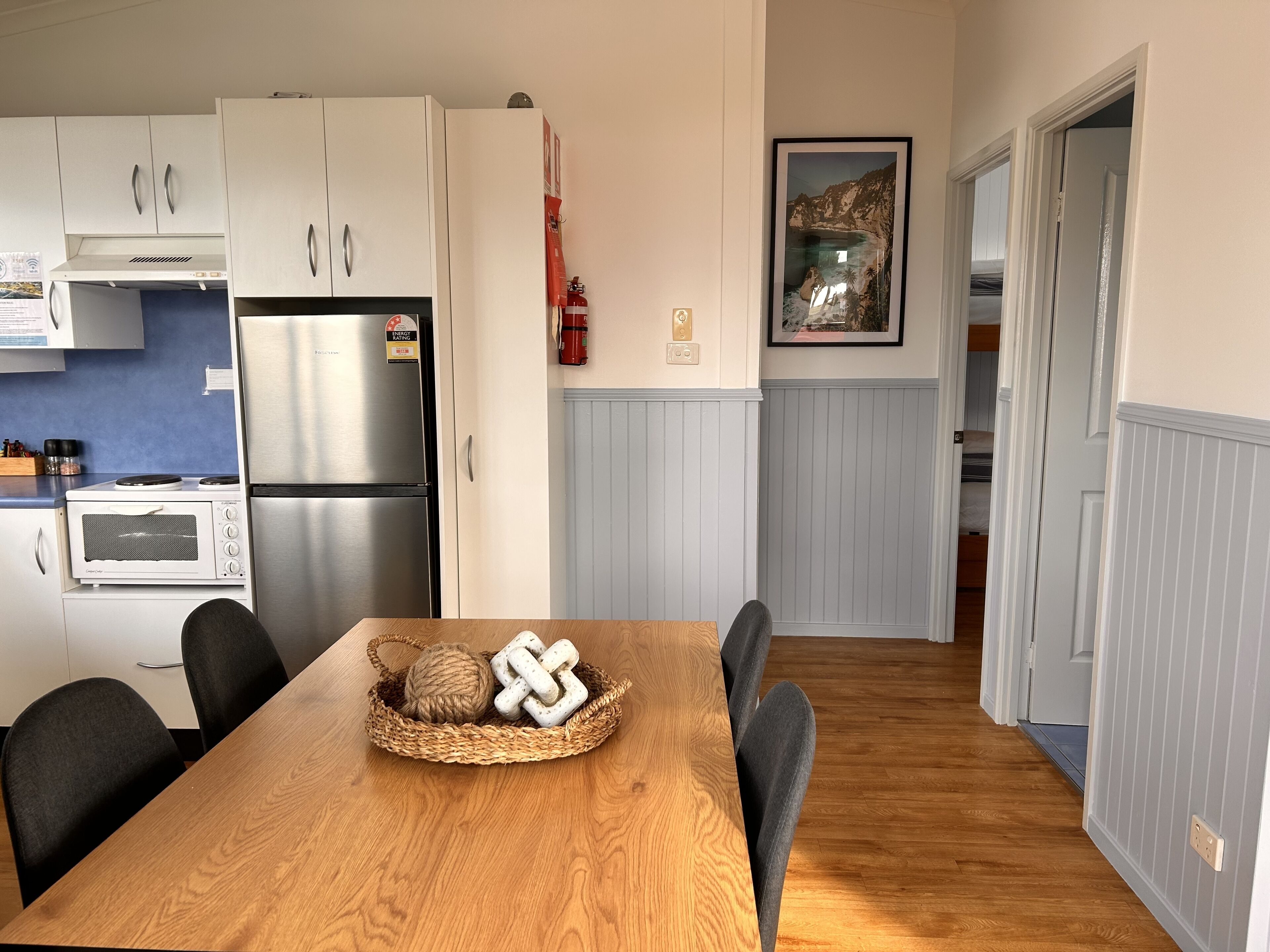 Eine moderne Küche mit weißen Schränken, einem Edelstahlkühlschrank und einem eingebauten Ofen.