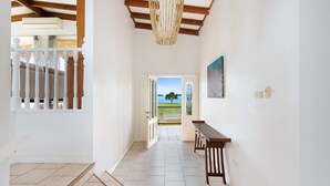 Un pasillo con un banco de madera, una lámpara colgante y una puerta que da al exterior.