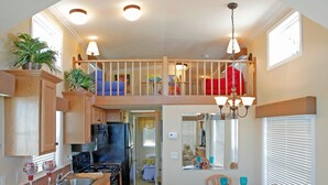 A spacious kitchen with wooden cabinets, a central island, and a dining area with chairs.