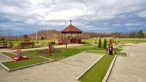 A park with a gazebo, benches, a small garden, and a walking path. - Indian Lakes RV Campground (Sunman)