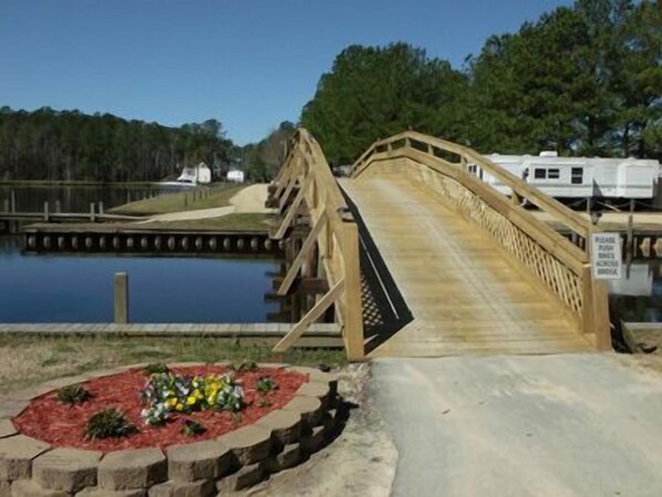 A wooden bridge over a body of water with a sign indicating a private road. - Twin Lakes RV & Camping Resort (Chocowinity)