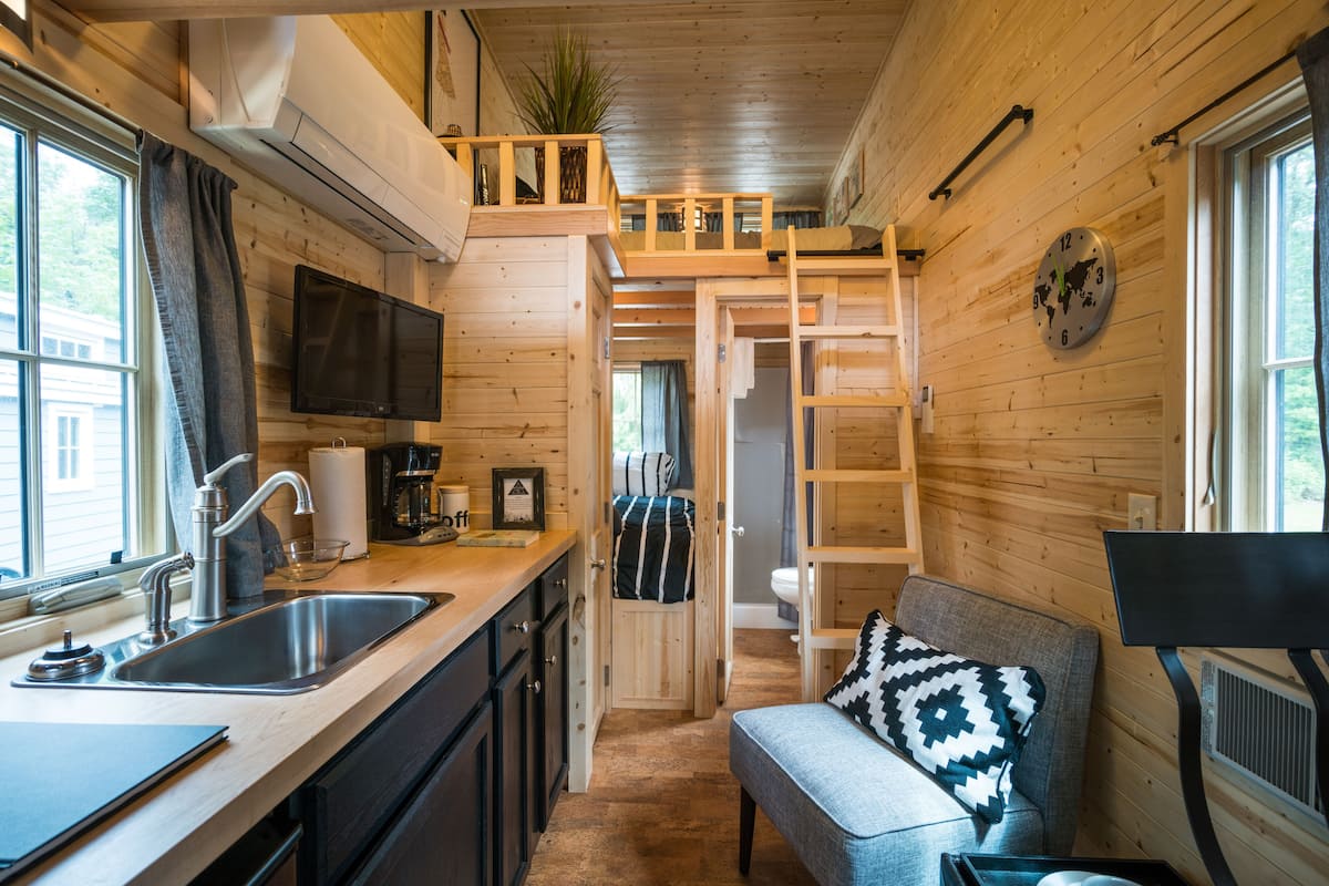 A compact kitchen with a sink, stove, and a small dining area.