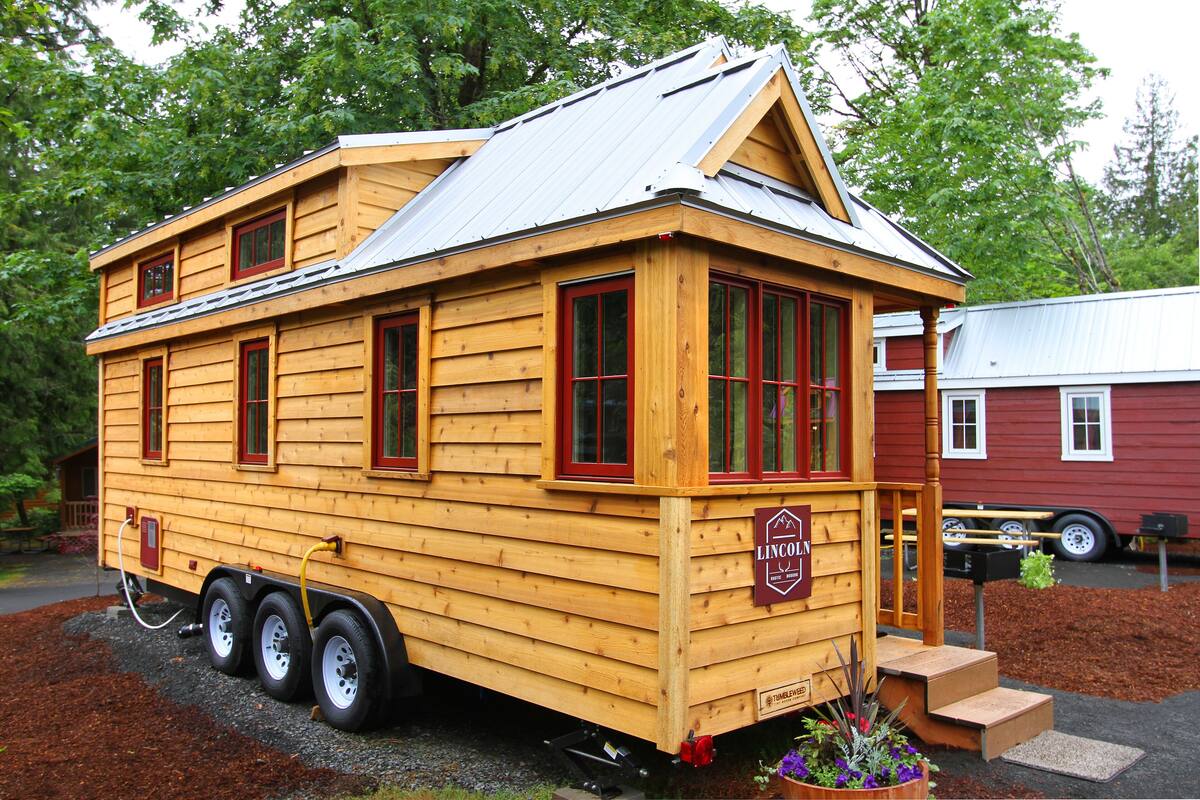 A wooden cabin with a metal roof, a small porch, and a sign that reads "Lincoln."