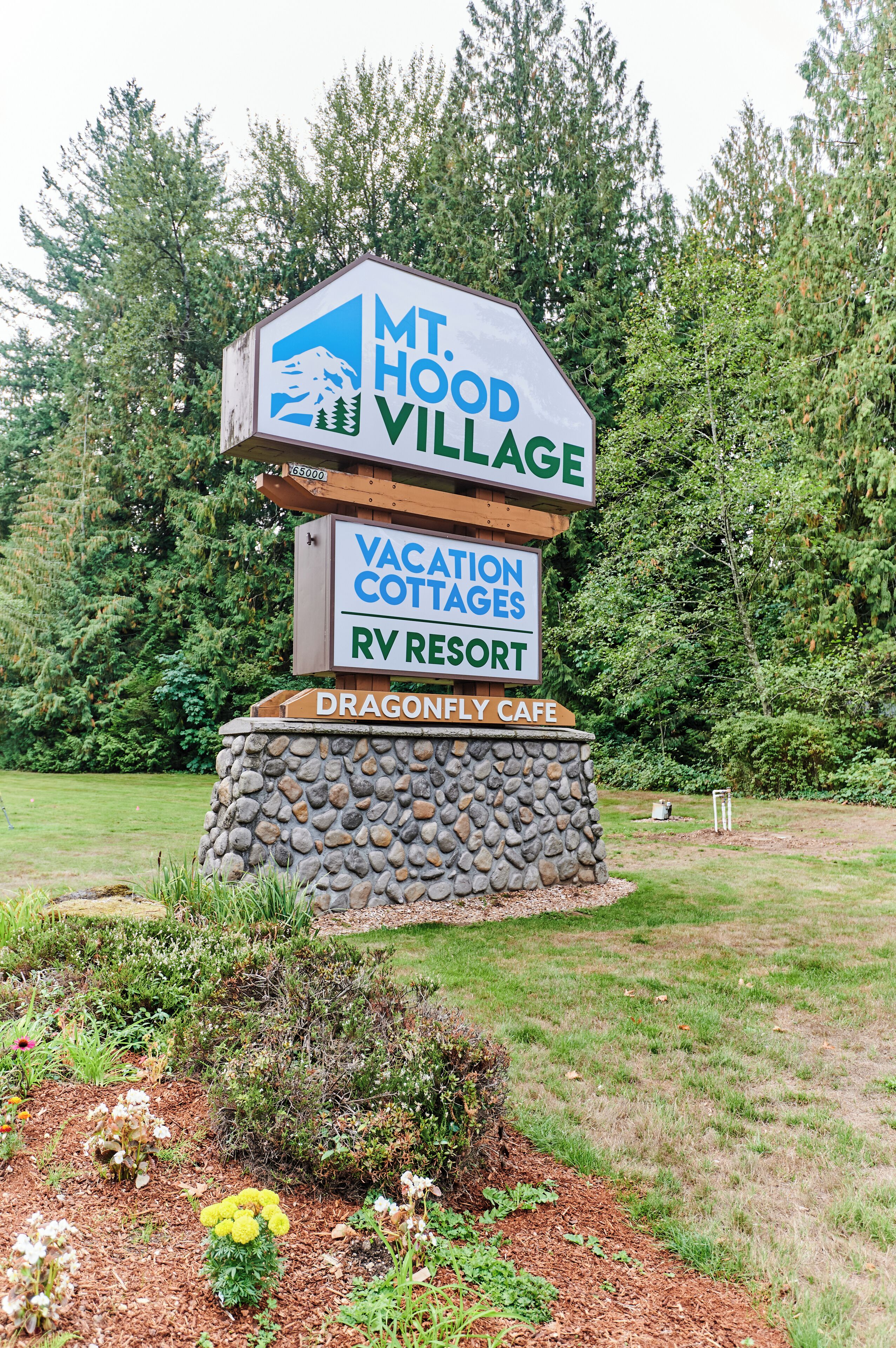 A sign for Mt. Hood Village, Vacation Cottages RV Resort, and Dragonfly Cafe.