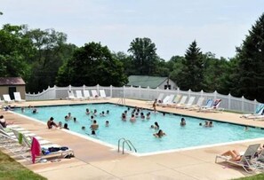 A swimming pool with multiple lanes, surrounded by lounge chairs and umbrellas.