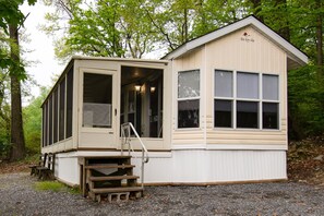 A small, single-story cabin with a sliding door and a small porch area.