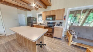 A modern kitchen with wooden cabinets, a central island, and a built-in oven. - Spring Gulch RV Campground (New Holland)