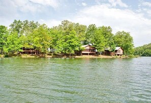A lakeside property with several wooden cabins surrounded by lush greenery.