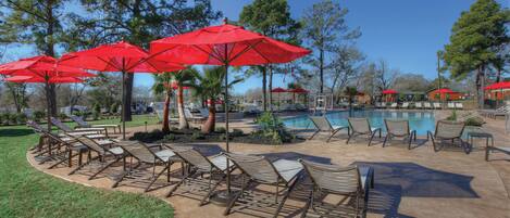 Una piscina al aire libre, sillones reclinables de piscina