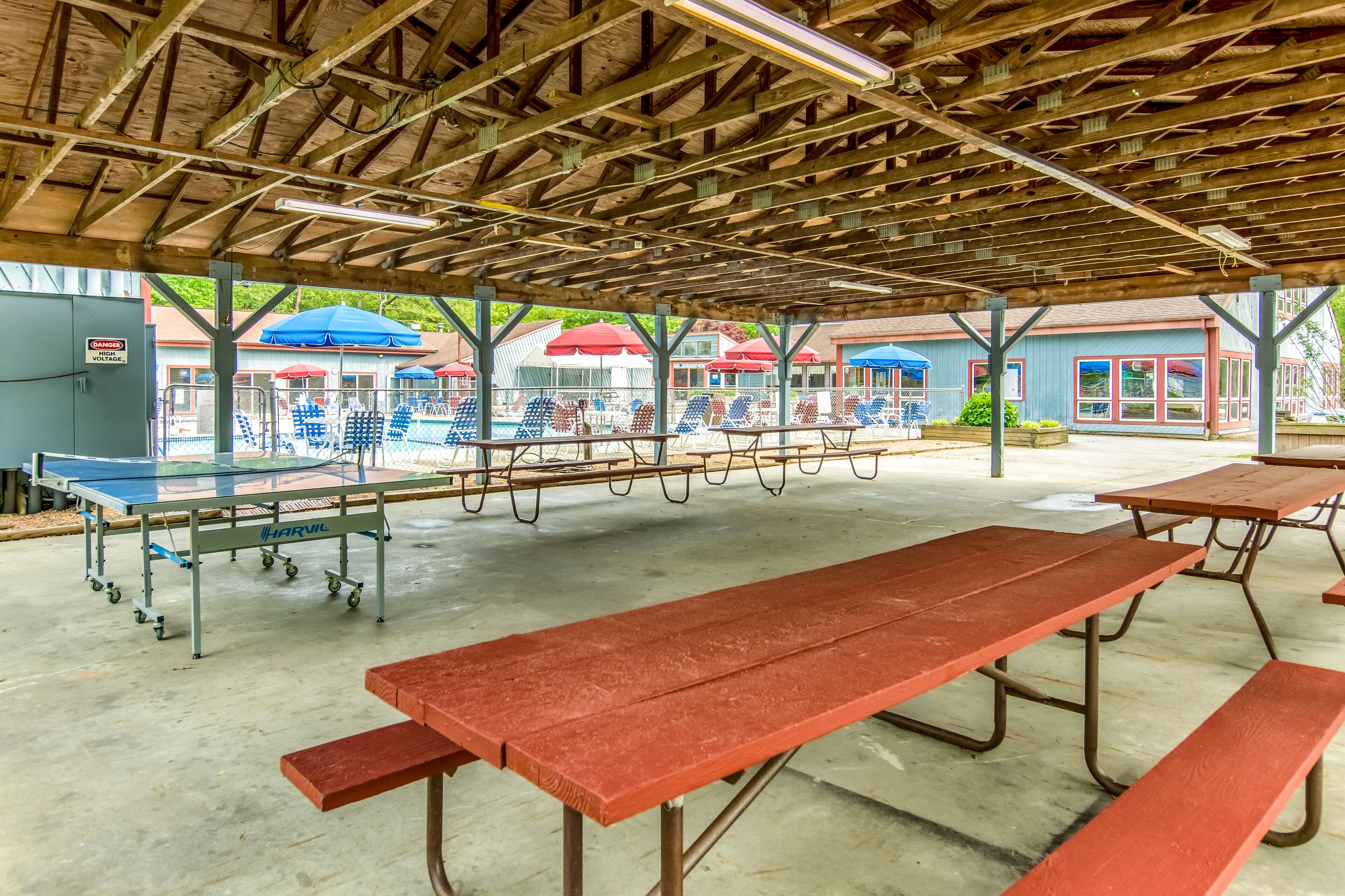 Un pabellón al aire libre con mesas de picnic y una mesa de ping pong.