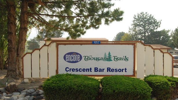 A sign for Encore Thousand Trails Crescent Bar Resort.