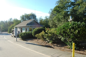 A small building with a sign reading "WELCOME CENTER" on a road with a parked golf cart. - La Conner RV & Camping Resort (La Conner)