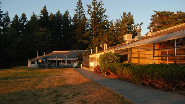 A building with a large glass facade, a covered outdoor area, and a pathway leading to the entrance. - La Conner RV & Camping Resort (La Conner)