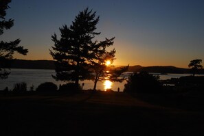 A sunset over a body of water with trees silhouetted against the sky. - La Conner RV & Camping Resort (La Conner)
