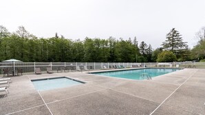 A rectangular outdoor pool with a white fence and lounge chairs. - Mount Vernon RV Campground (Bow)