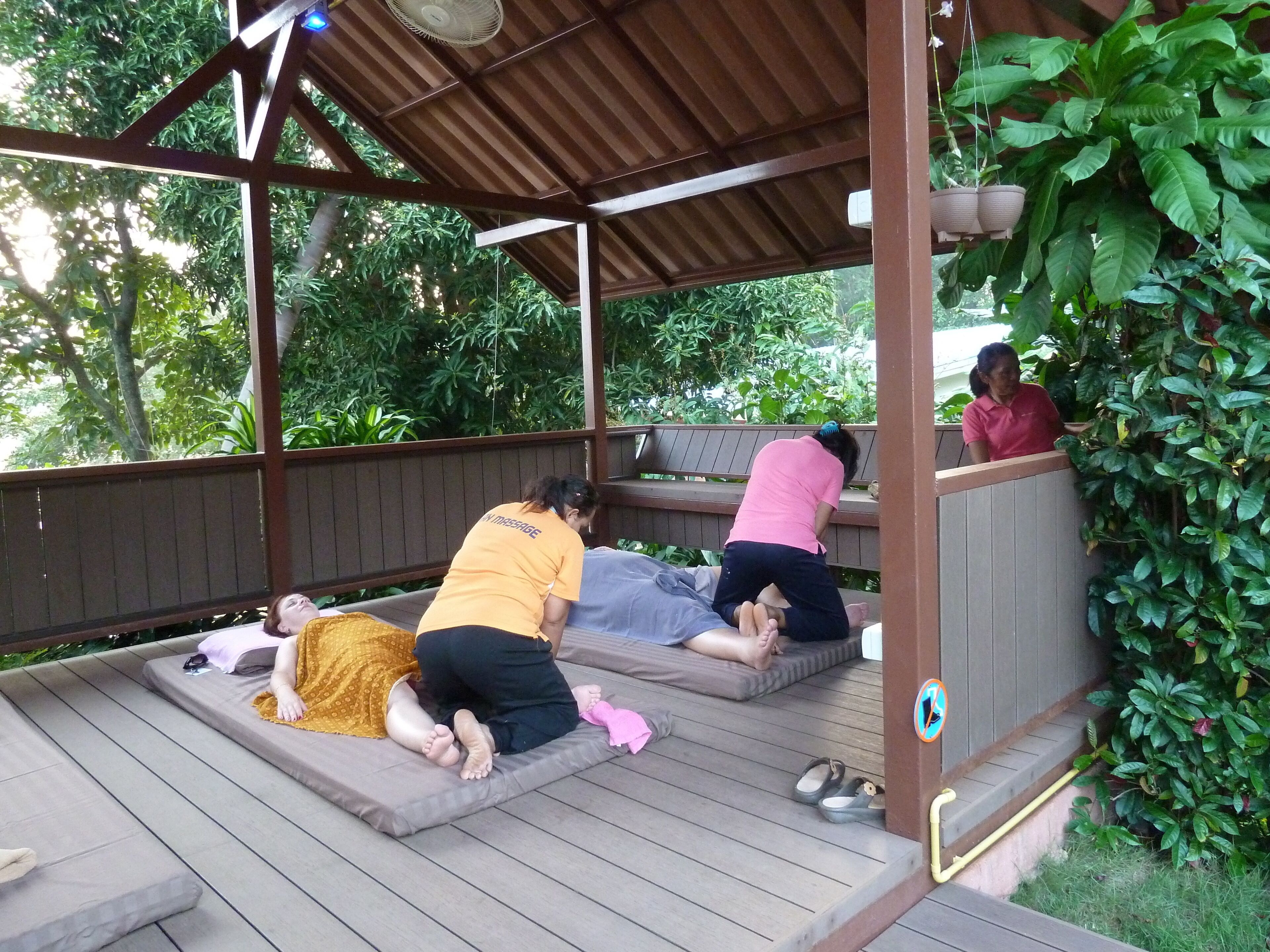 A covered outdoor area with wooden flooring and benches.