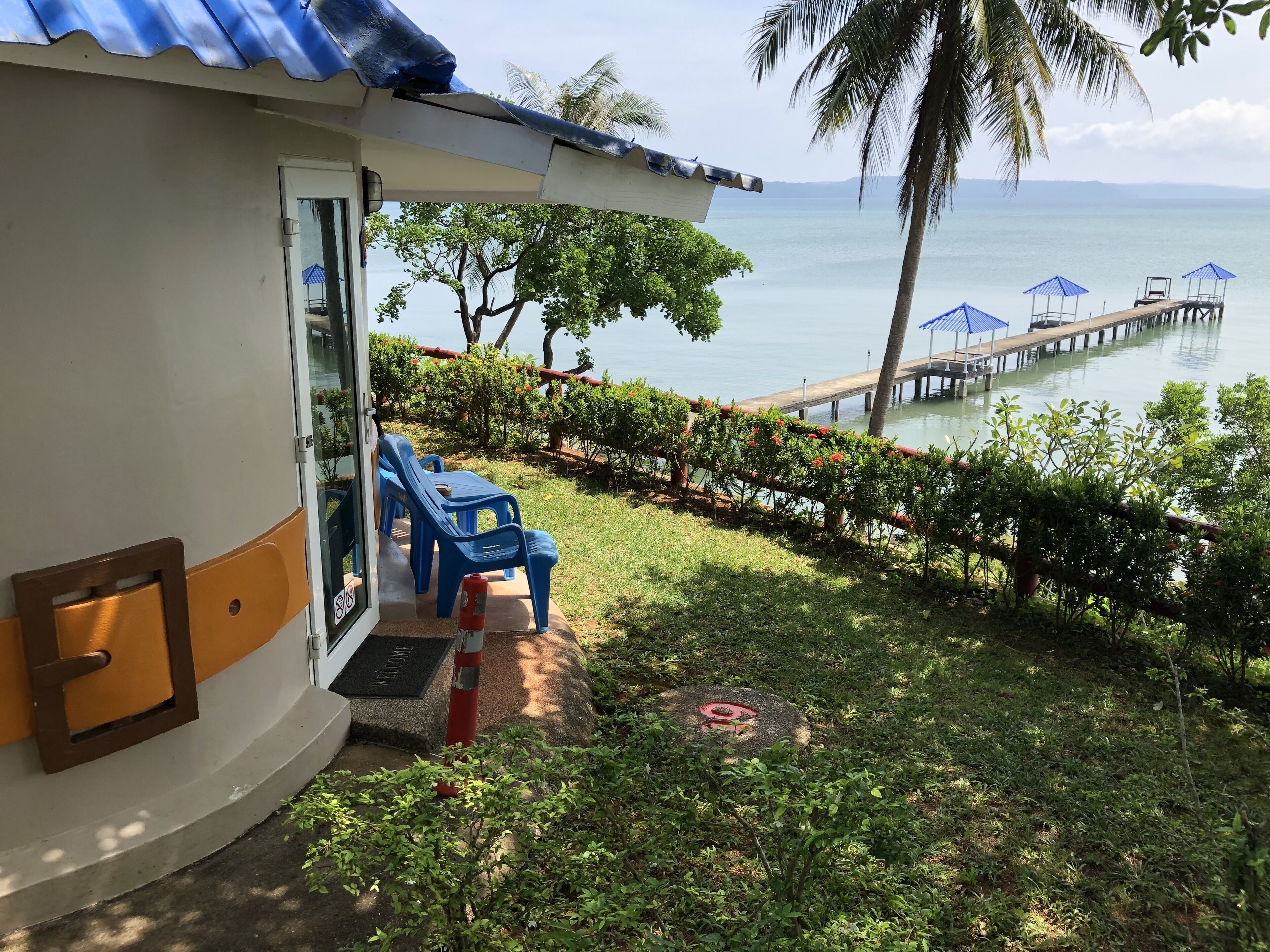 A view from a building's entrance overlooking a body of water, with a dock extending into the water.