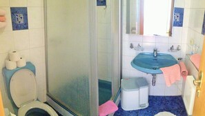 A bathroom with a toilet, shower, sink, and a mirror. - Hotel-Restaurant Rosengarten (Zell am Ziller)