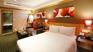 Ein Hotelzimmer mit einem großen Bett, einem Schlafsofa, einem Nachttisch und einer Wandlampe.