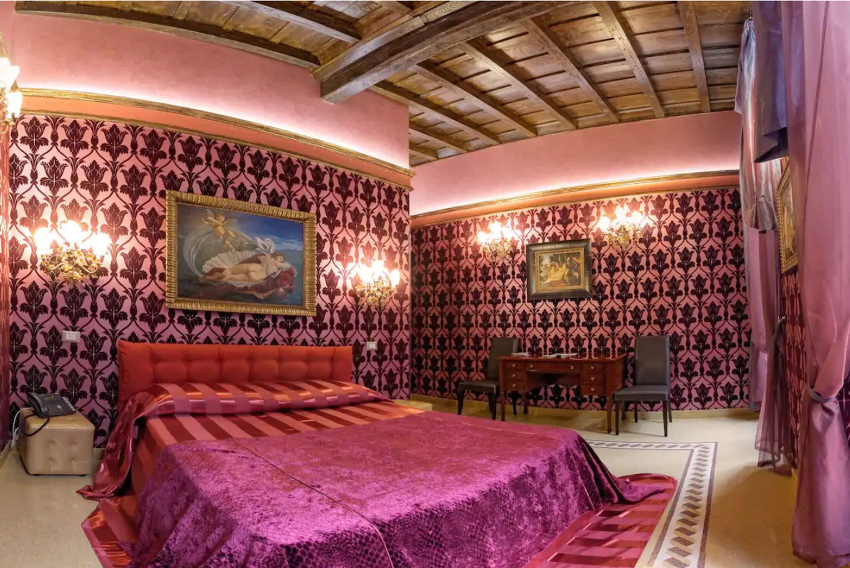 A bedroom with a large bed, a desk, and a chair.