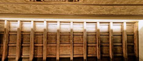 A ceiling with intricate carvings and a wooden panel structure.