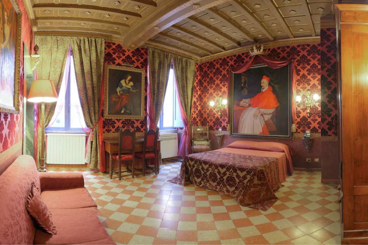 A room with a checkered floor, a bed, a desk, and a chair.