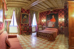 Um quarto com piso xadrez, uma cama, uma escrivaninha e uma cadeira.