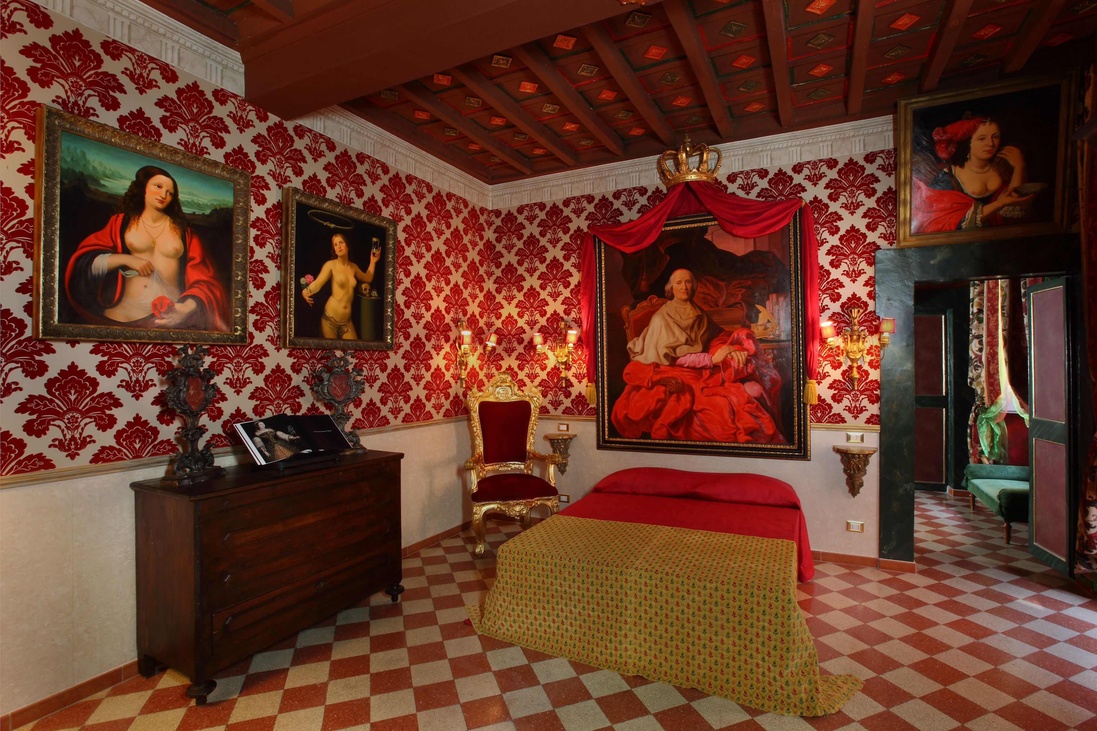 A room with a checkered floor, a wooden dresser, a bed with a red bedspread, and a large painting of a woman in red on the wall.